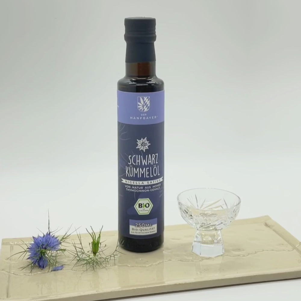 Eine Flasche Schwarzkümmelöl wird in ein Glas gefüllt